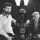 Today is George Lucas’ birthday, seen here with Empire Strikes Back director Irvin Kershner and some guy in a black suit.